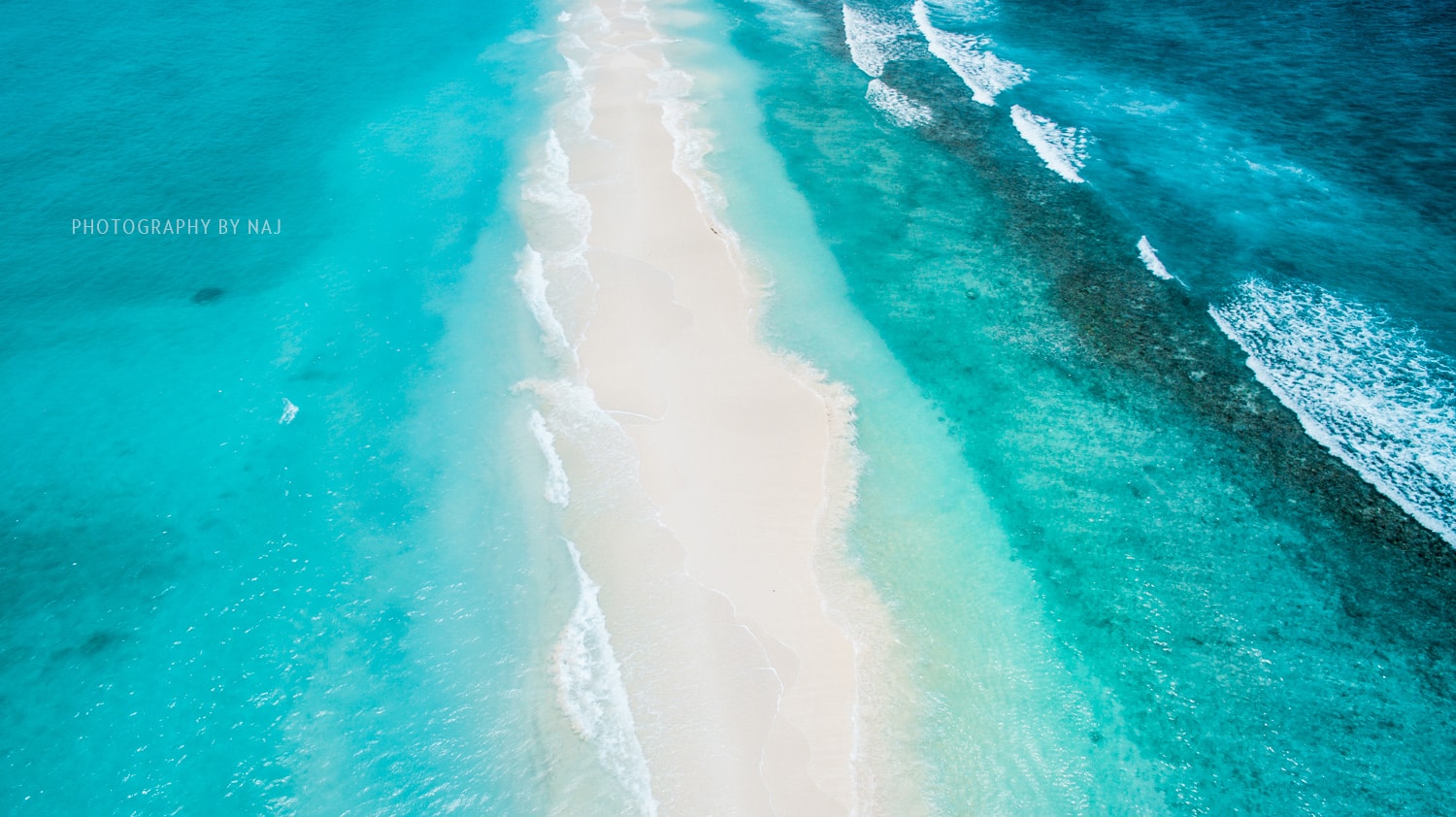 Sandbank lapped on both sides by the turquoise Indian Ocean in the Maldives